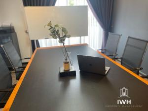 - une table avec un ordinateur portable et un vase dans l'établissement Ipoh 19A Villa for 12pax 6 Carpark with BBQ by IWH, à Ipoh