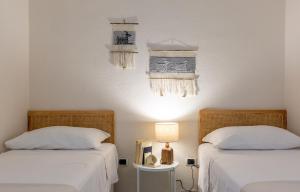 NotteriにあるPatio Relax - 200m from beach - Villasimiusのベッド2台、テーブル(ランプ付)が備わる客室です。