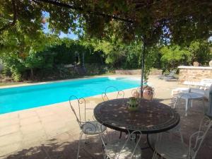 a table and chairs in front of a swimming pool at Tiny House de la Côte Roannaise in Ambierle