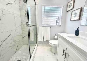 y baño con ducha, aseo y lavamanos. en Downtown West Palm Apartment Near Airport en West Palm Beach