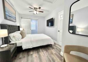 1 dormitorio con cama blanca y espejo en Downtown West Palm Apartment Near Airport en West Palm Beach