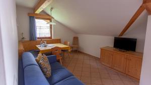 sala de estar con sofá azul y TV en Pretzerhof, en Campo di Trens