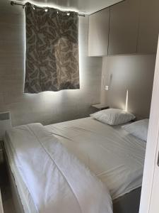 um quarto com uma grande cama branca e uma janela em Domaine Les Nids du Lac em Sanchey