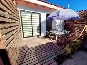 a wooden deck with a bench and an umbrella at Cabañas Garcia in Algarrobo