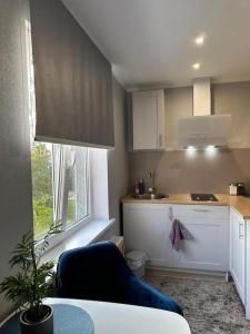 a kitchen with a blue chair and a table in a room at Hugo 2 in Jēkabpils +3 photos