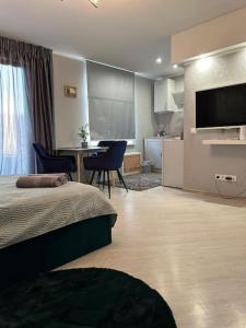 a bedroom with a bed and a kitchen with a table at Hugo 2 in Jēkabpils