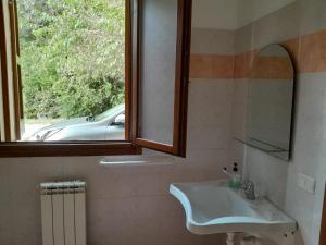 baño con lavabo y ventana en La Rizza, en Bentivoglio