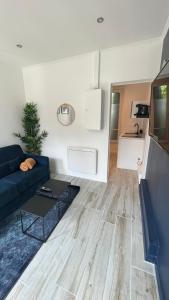 ein Wohnzimmer mit einem Sofa und einem Tisch in der Unterkunft L’oasis urbaine - Charmant studio proche de Paris in Alfortville