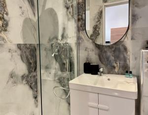 een badkamer met een wastafel en een spiegel bij L’oasis urbaine - Charmant studio proche de Paris in Alfortville