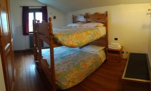 a bedroom with two bunk beds and a window at Rifugio "Mai Tardi" in Madesimo