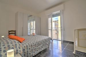 een slaapkamer met een bed met een oranje kussen erop bij Mariani's Home in Finale Ligure