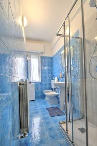 een blauwe badkamer met een douche en een toilet bij Mariani's Home in Finale Ligure