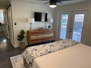 a bedroom with a bed and a dresser and a tv at Brentwood de Maria -Cowboy Pool & Dog Friendly in Austin +24 photos