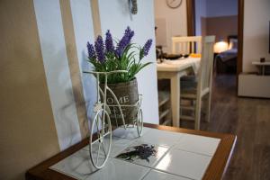 een vaas met paarse bloemen op een tafel bij Getaway Tirana City Center - STAYcation Apartments in Tirana