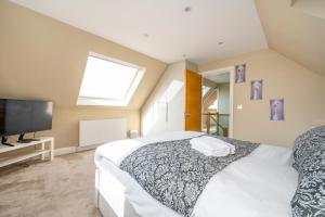 um quarto com uma cama grande e uma televisão de ecrã plano em *RA7C* For your most relaxed & Cosy stay + Free Parking + Free Fast WiFi * em Batley