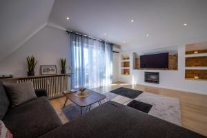 a living room with a couch and a tv at Renatas Ferienwohnung Sasbachwalden in Sasbachwalden