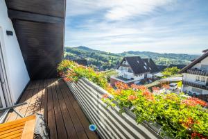 Elle comprend un balcon fleuri offrant une vue sur une maison. dans l'établissement Renatas Ferienwohnung Sasbachwalden, à Sasbachwalden