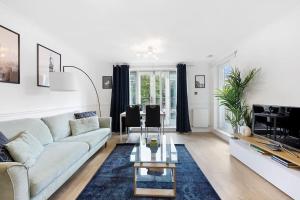 een woonkamer met een bank en een tafel bij 3-bed apartment in Limehouse in Londen
