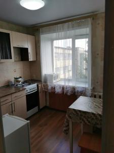 a small kitchen with a stove and a window at 1 комн апартаменты в центре рядом с парком in Kostanay