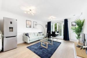 een witte woonkamer met een bank en een tafel bij 3-bed apartment in Limehouse in Londen