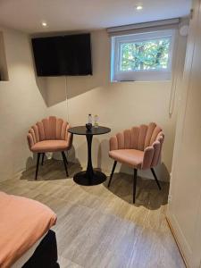 um quarto com duas cadeiras e uma mesa e uma televisão em Stad och strand i Höganäs em Höganäs