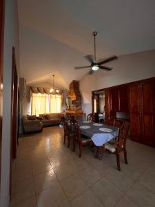 a living room with a table and a ceiling fan at Casa familiar en Boquete in Boquete