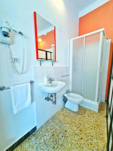 Un baño con lavabo, inodoro y espejo. en LC ROOMS Pisa, en Pisa