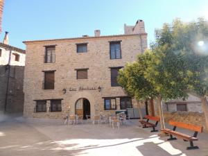 a brick building with tables and chairs in front of it at Las Abadías in San Felices