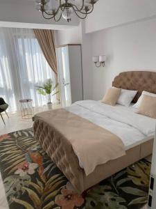 a bedroom with a large bed with a rug at Elite Apartment in Sibiu