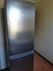einem Kühlschrank aus rostfreiem Stahl in einer Ecke eines Zimmers in der Unterkunft 1 комн квартира в центре in Qostanai