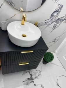 a bathroom with a white sink on a black cabinet at Elite Apartment in Sibiu