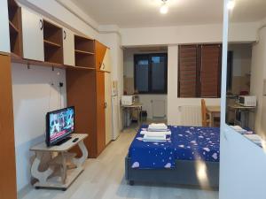 a room with a bed and a television in it at Bya Concept in Iaşi