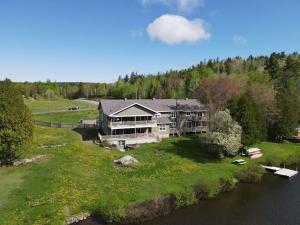 an aerial view of a large house on a river at Equipped condo on St-Pierre Lake, Kamouraska RCM in Mont-Carmel