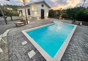a swimming pool in front of a house at Chalet Grotta Monte Etna in Maletto