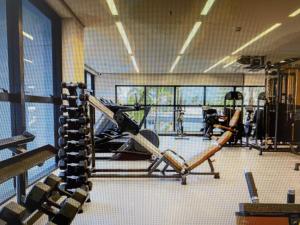 einen Fitnessraum mit Kardiogeräten in einem Zimmer mit Fenstern in der Unterkunft Salinas Premium Resort Ap 1 QT in Salinópolis