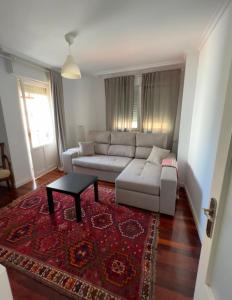 a living room with a white couch and a rug at Apartamento en Casco Histórico a 300 metros de la playa in Castro-Urdiales