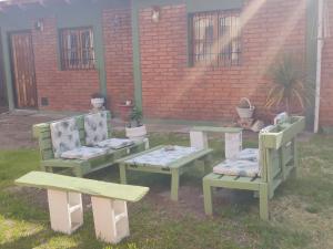 Un grupo de bancos y mesas en un patio. en F R F departamentos turisticos, en San Rafael