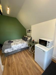 a bedroom with a bed with a microwave and a table at London Guest Studios 8 in London