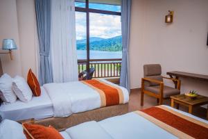 博卡拉Hotel Fewa Camp的有两张床和一个阳台的酒店房间