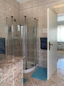 a bathroom with a shower and a glass door at Casa Paraiso studio salon coin repas kitchenette extérieure grande terrasse privée jardin et piscine près des plages de FUSETA et de la RIA FORMOSA in Moncarapacho