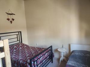 1 dormitorio con cama y mesa pequeña en F R F departamentos turisticos en San Rafael