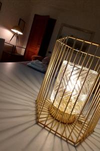 Una jaula dorada sobre una cama en La Casa del Sole en Carpi