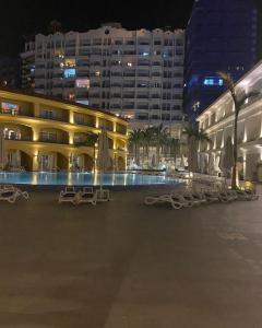 a large building with a swimming pool at night at PORTO MARINA TOWERS SEA & POOL VIEW North Coast in El Alamein