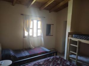 Una pequeña habitación con dos camas y una ventana. en F R F departamentos turisticos, en San Rafael