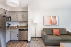 a living room with a couch and a kitchen at Candlewood Suites Eagan - Mall of America Area by IHG in Eagan