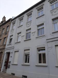 ein weißes Gebäude mit Fenstern auf einer Straße in der Unterkunft Gemütliche Wohnung in Burg in Burg bei Magdeburg