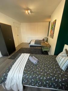 a bedroom with two beds and a table in it at Willesden Green ROOMS in London