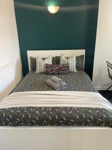 a large bed with pillows on top of it at Willesden Green ROOMS in London
