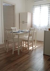 a kitchen with a table and chairs and a refrigerator at IL GUFO DELLA MARZA in Ispica