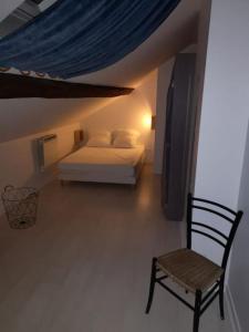 a bedroom with a bed and a chair in a room at Hypercentre résidence paisible in Fontainebleau